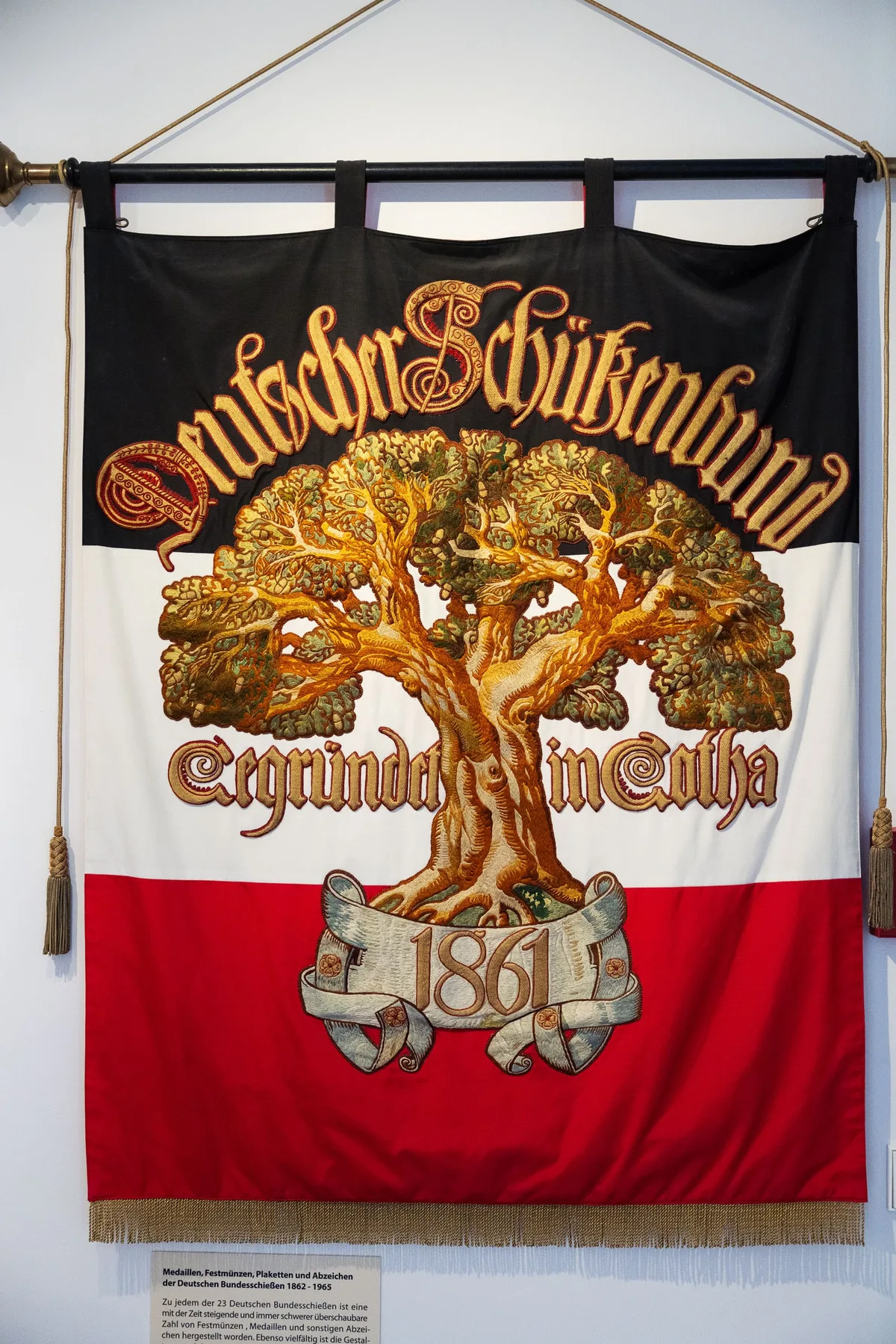 Hochformat: Historische Fahne mit gestickter Eiche, Schriftband mit der Jahreszahl 1861 und goldener Fransenborte