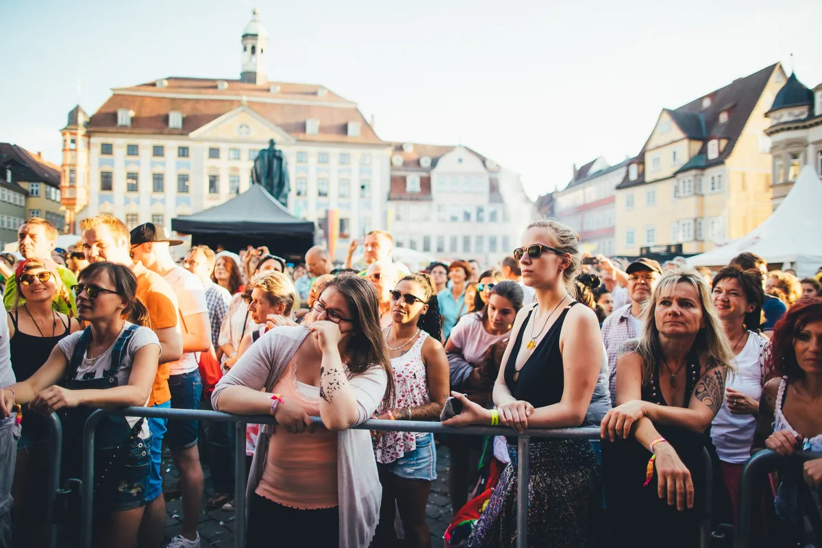 Dichte Zuschauerreihe am Absperrgitter auf dem Coburger Marktplatz, dahinter das Standbild und die Stadtfassaden
